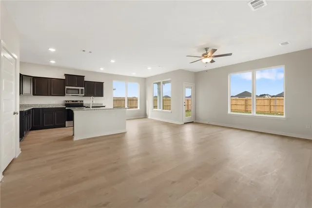 a view of a livingroom with a kitchen stove and wooden floors