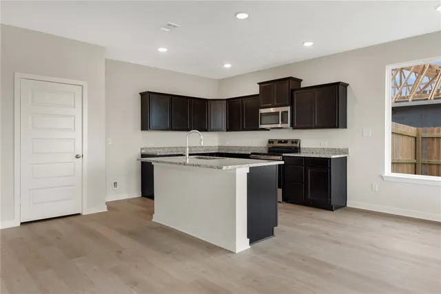 a kitchen with stainless steel appliances granite countertop a sink stove and cabinets