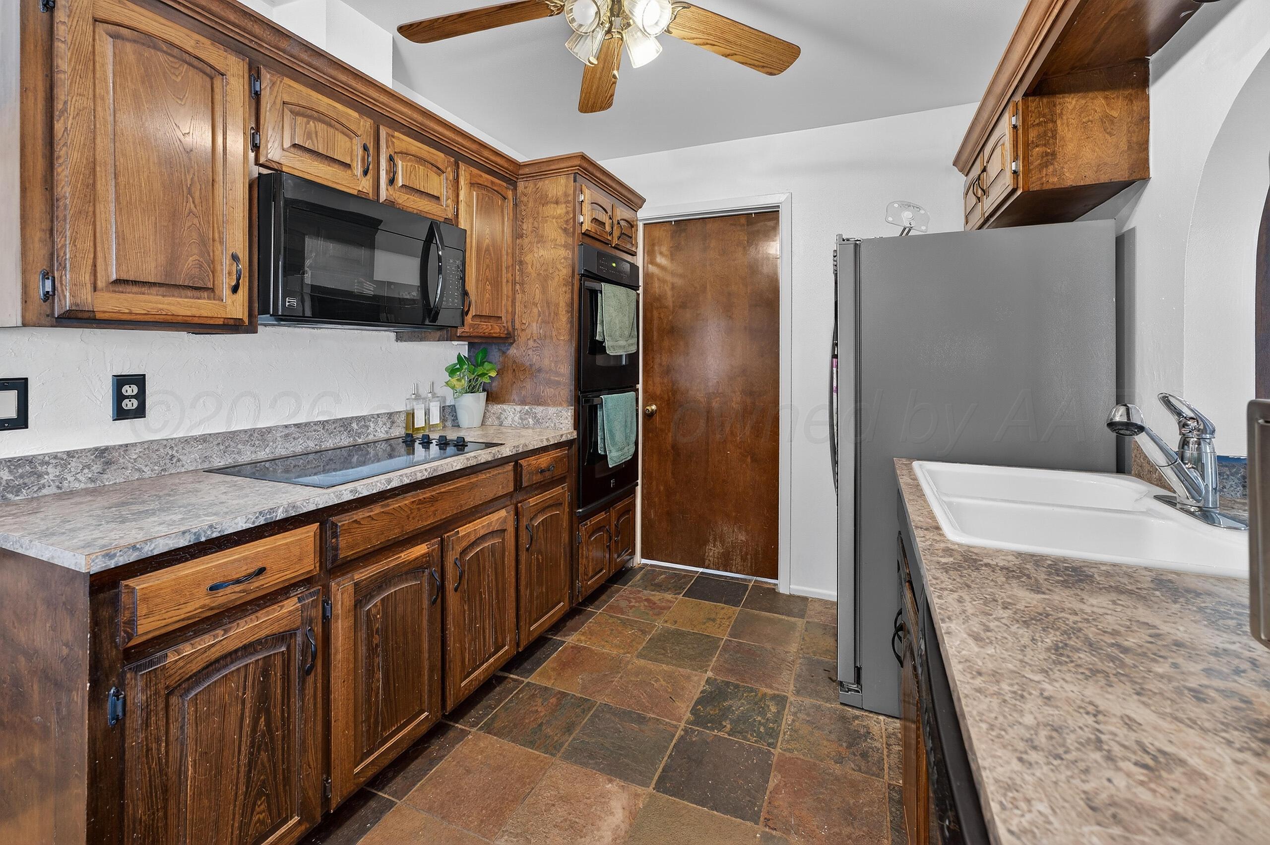 6307 Fulton Drive Amarillo, TX 79109 - Photo 7 of 23 a kitchen with stainless steel appliances granite countertop a sink stove and refrigerator