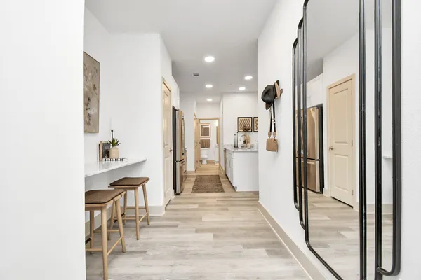 a view of a hallway with wooden floor windows and a living room