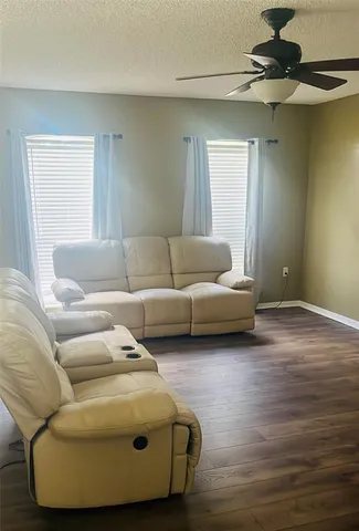 a living room with furniture and a wooden floor
