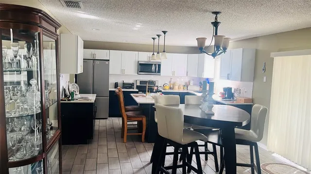 a view of a dining room and livingroom with furniture wooden floor a chandelier