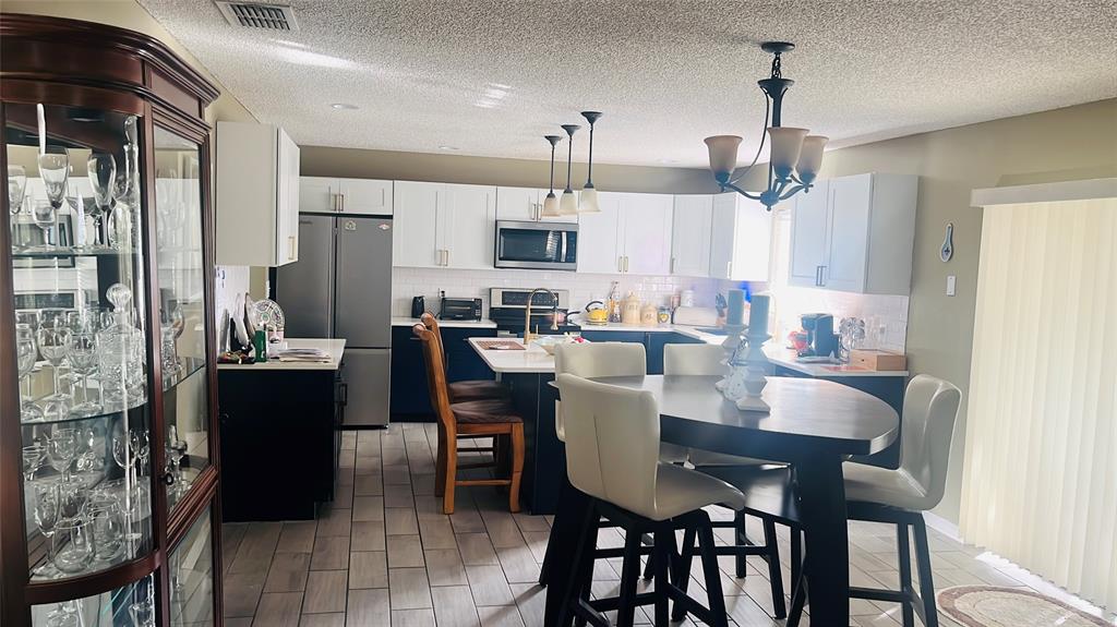 184 Massini Avenue Northwest Palm Bay, FL 32907 - Photo 7 of 15 a view of a dining room and livingroom with furniture wooden floor a chandelier