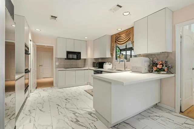 a kitchen with granite countertop a sink and a stove top oven