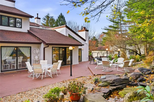 a view of a patio with table and chairs potted plants and large tree