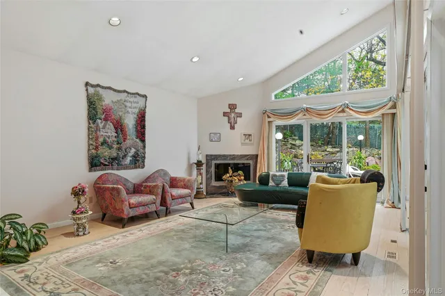 a living room with furniture a large window and a fireplace