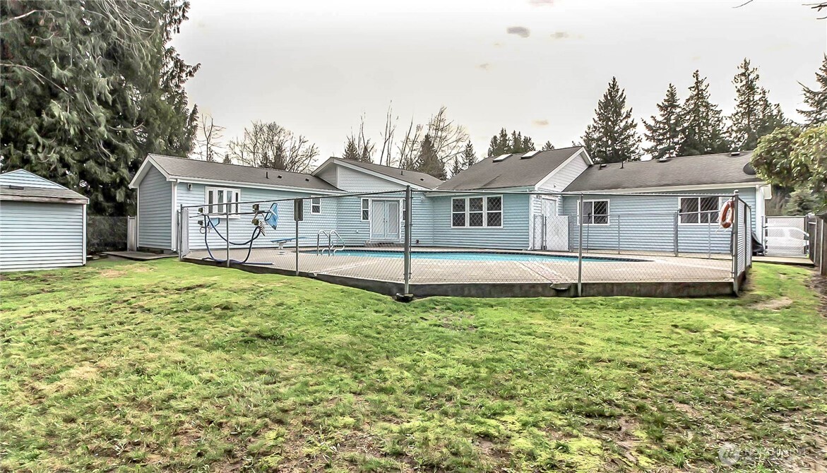 1005 28th Street Southeast, Unit C Auburn, WA 98002 - Photo 4 of 23 a white house with a small yard and wooden fence