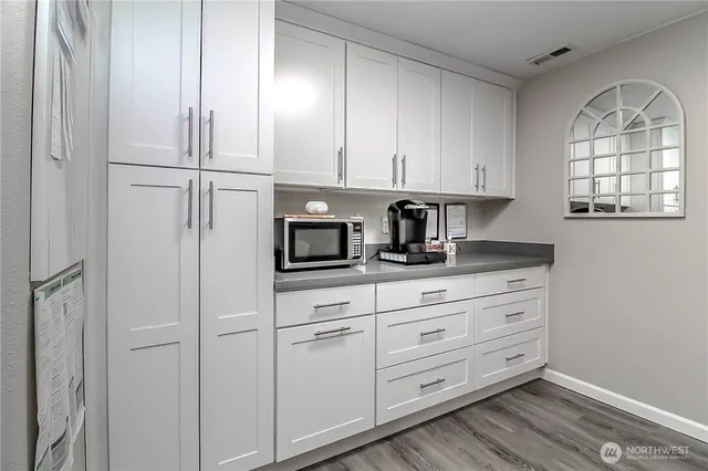 a kitchen with white cabinets and white appliances