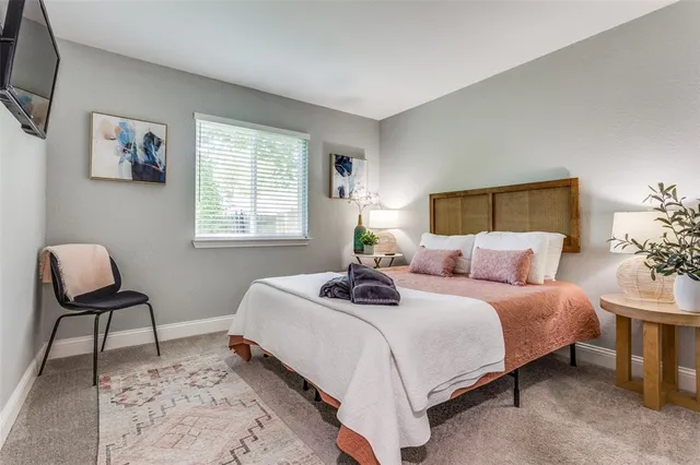 a bedroom with a bed a couch and a potted plant on the dresser