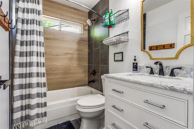 a bathroom with a granite countertop sink a toilet and shower
