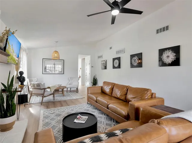 a living room with furniture kitchen view and a window