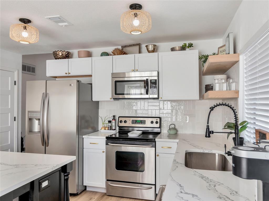 109 Mapleridge Drive Rockwall, TX 75032 - Photo 6 of 16 a kitchen with granite countertop a refrigerator stove and sink