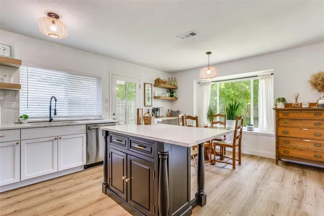 a kitchen with a table chairs and wooden floor
