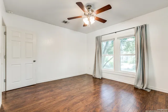 wooden floor in an empty room with a window
