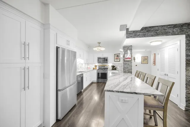 a kitchen with white cabinets and stainless steel appliances