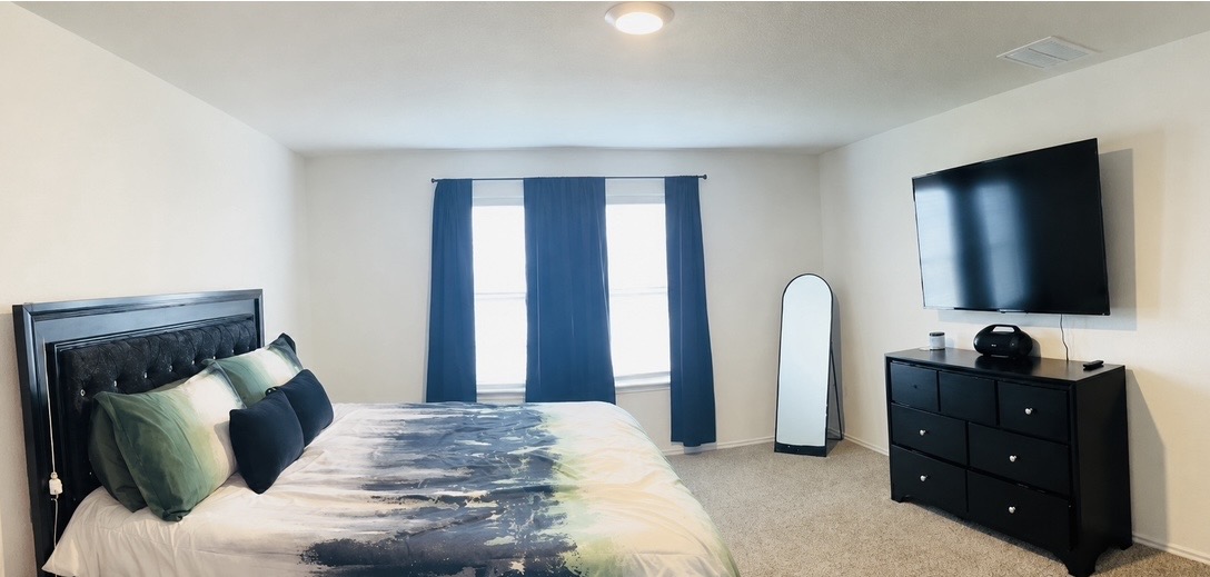 14817 Perlino Way, Unit A Manor, TX 78653 - Photo 19 of 40 a bedroom with a bed and a flat screen tv