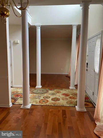 a view of a livingroom with wooden floor and a fireplace