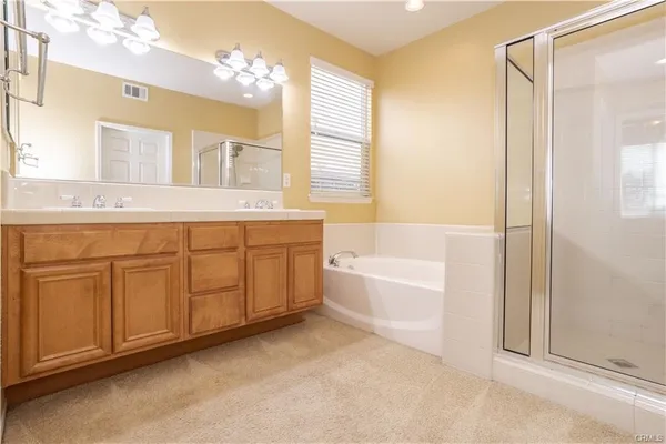 a spacious bathroom with a tub sink and mirror
