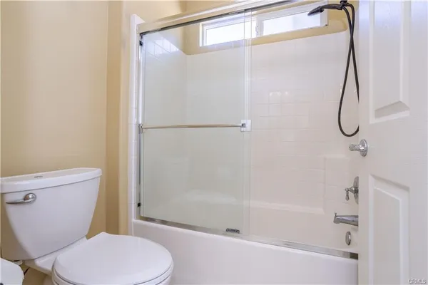 a white toilet sitting next to a bath tub shower