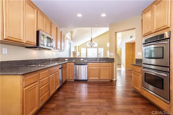a large kitchen with stainless steel appliances granite countertop a stove and a sink