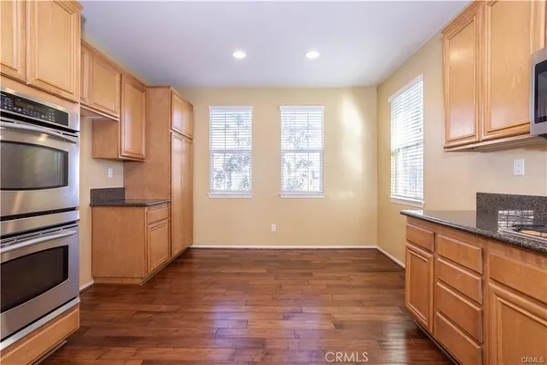 a kitchen with granite countertop wooden floors and stainless steel appliances