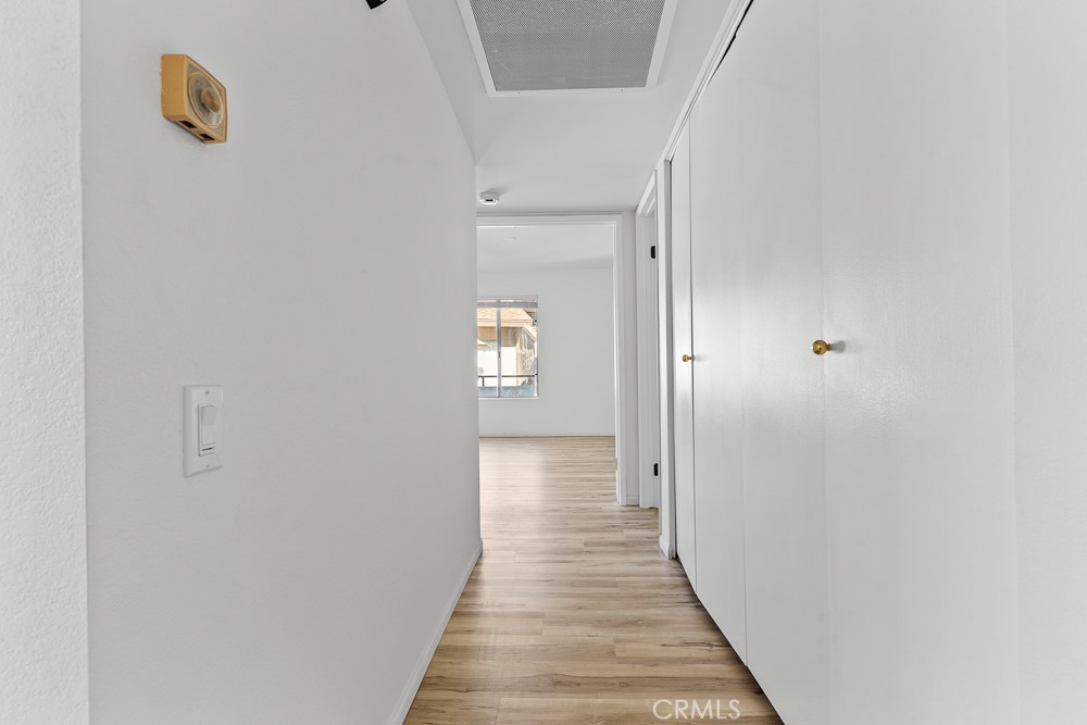21921 Rimhurst Drive, Unit 128 Lake Forest, CA 92630 - Photo 12 of 24 a view of a hallway with wooden floor and a bathroom