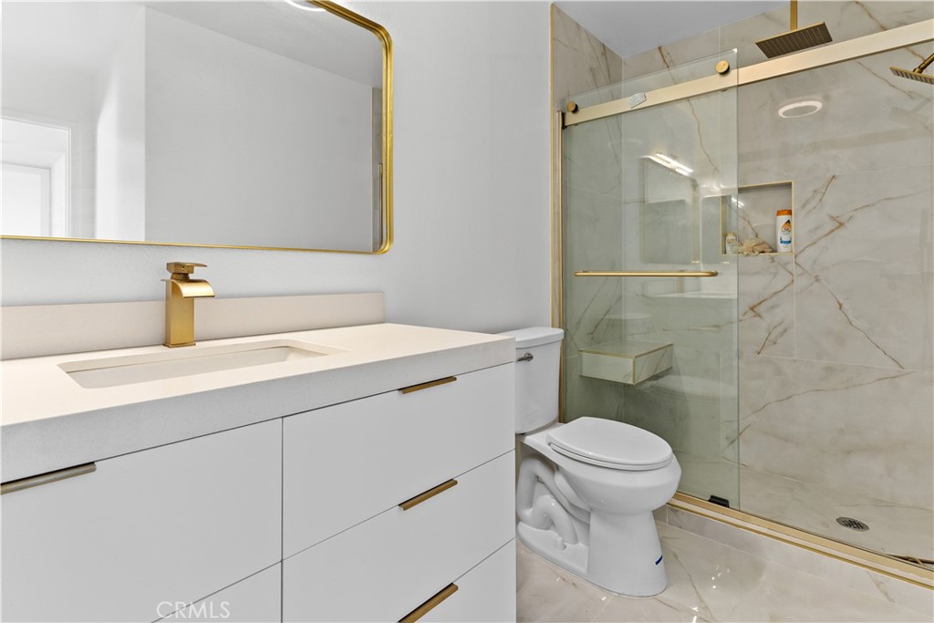 21921 Rimhurst Drive, Unit 128 Lake Forest, CA 92630 - Photo 19 of 24 a bathroom with a sink a toilet and shower