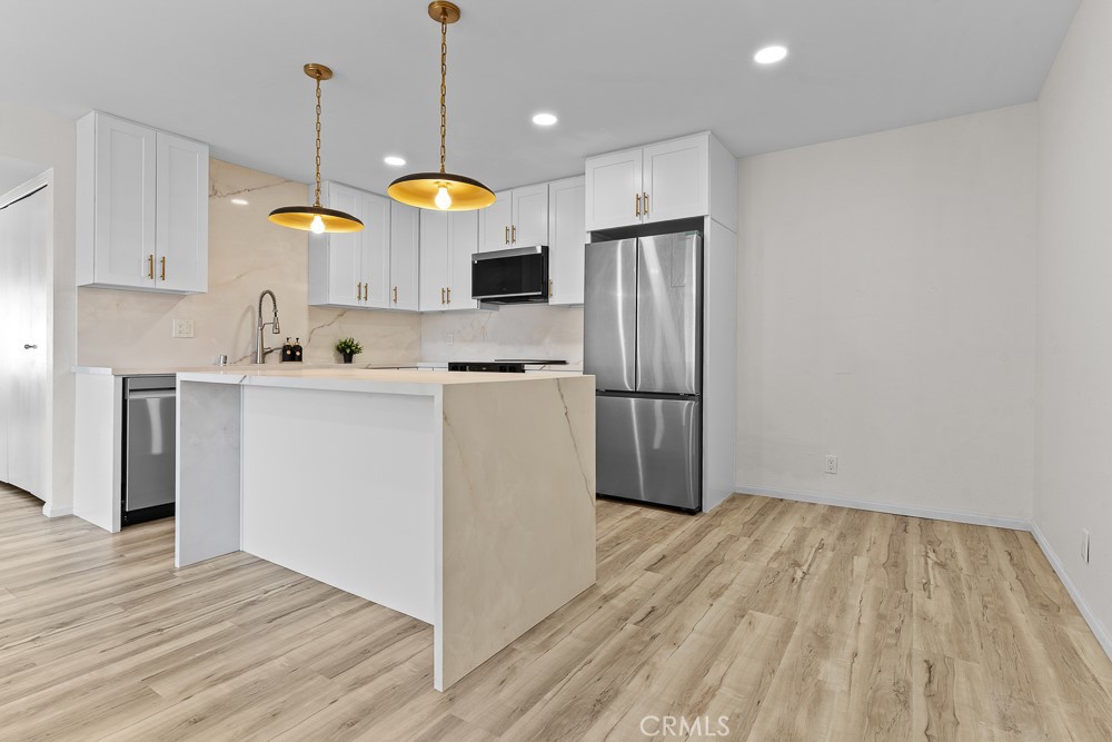 21921 Rimhurst Drive, Unit 128 Lake Forest, CA 92630 - Photo 3 of 24 a kitchen with cabinets and wooden floor