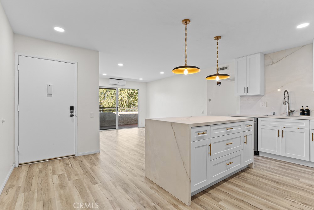 21921 Rimhurst Drive, Unit 128 Lake Forest, CA 92630 - Photo 7 of 24 a kitchen with white cabinets and stainless steel appliances