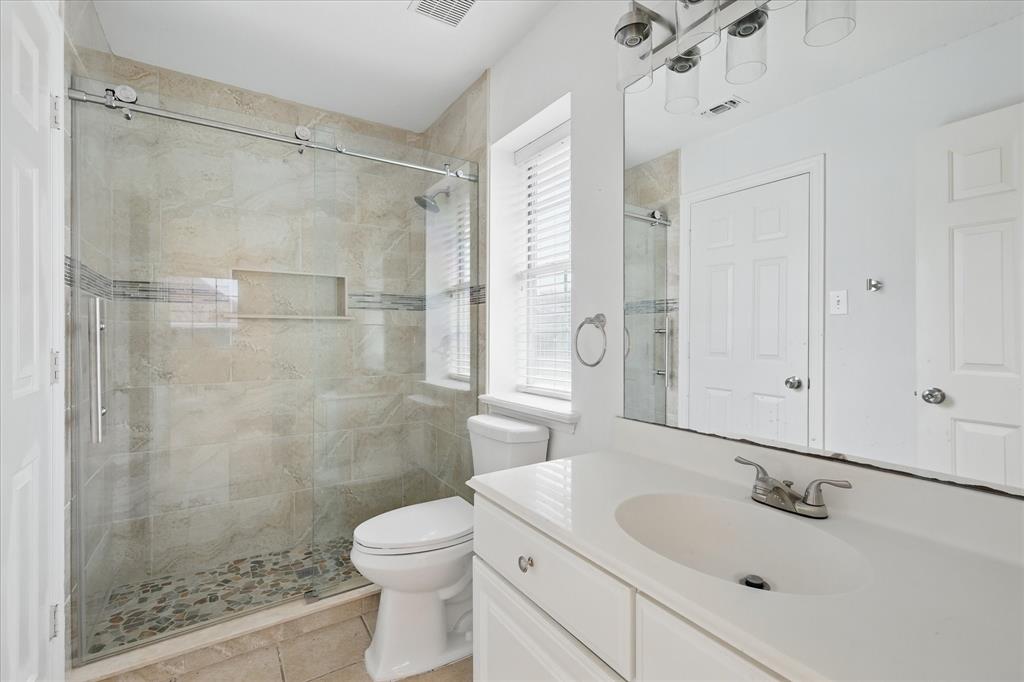 14625 Windsor Court Addison, TX 75001 - Photo 26 of 40 a bathroom with a sink mirror and a shower