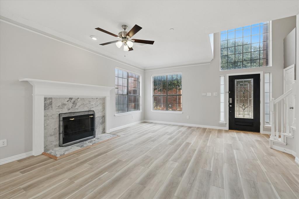 14625 Windsor Court Addison, TX 75001 - Photo 6 of 40 a view of an empty room with wooden floor fireplace and a window