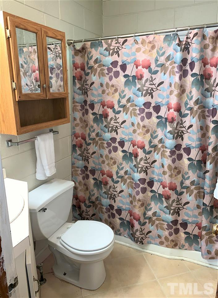 464 Rose Lane Raleigh, NC 27610 - Photo 2 of 5 a white toilet sitting next to a shower curtain