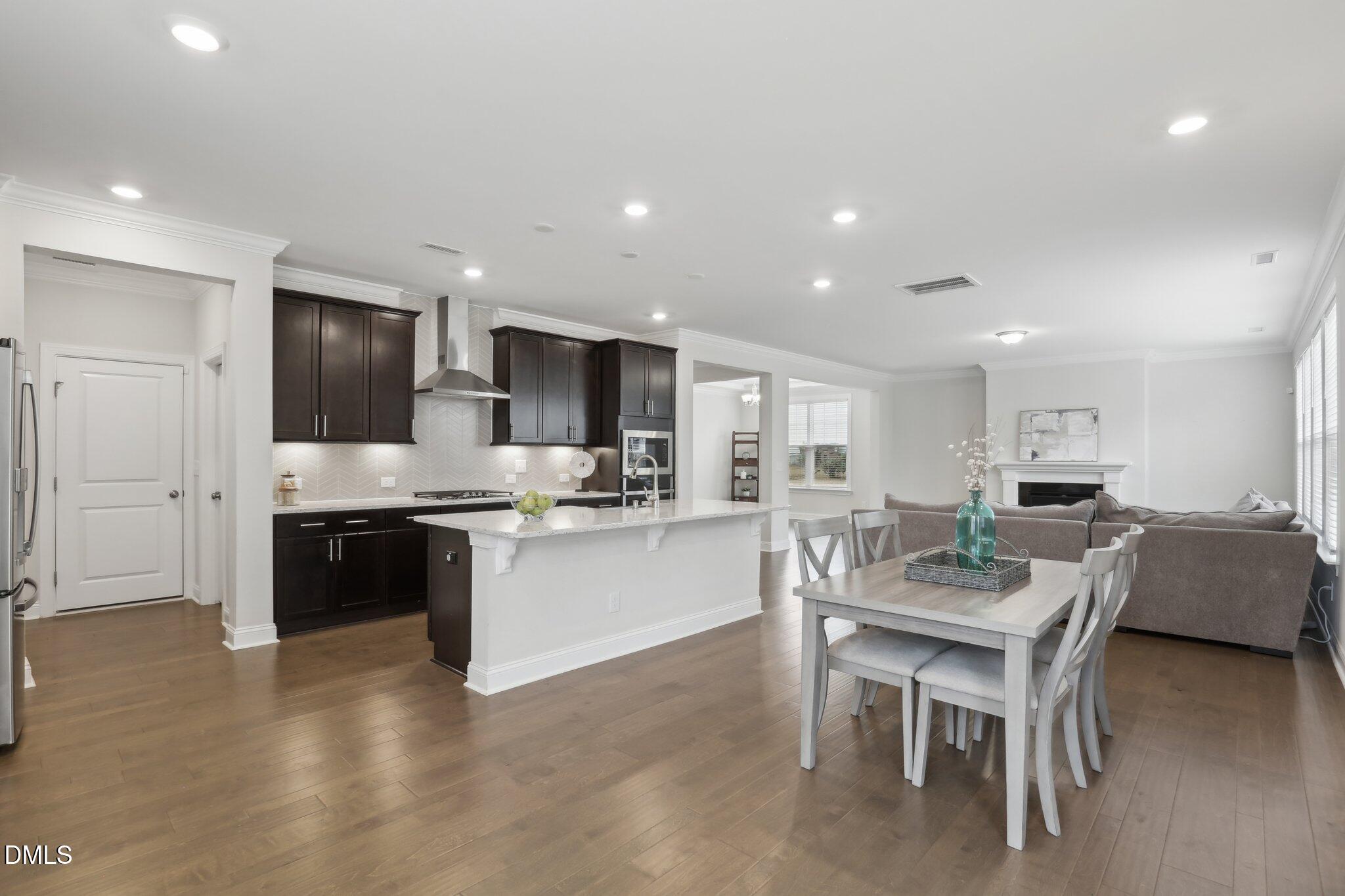 1829 Knights Crest Way Wake Forest, NC 27587 - Photo 18 of 45 a kitchen with a dining table chairs refrigerator and microwave