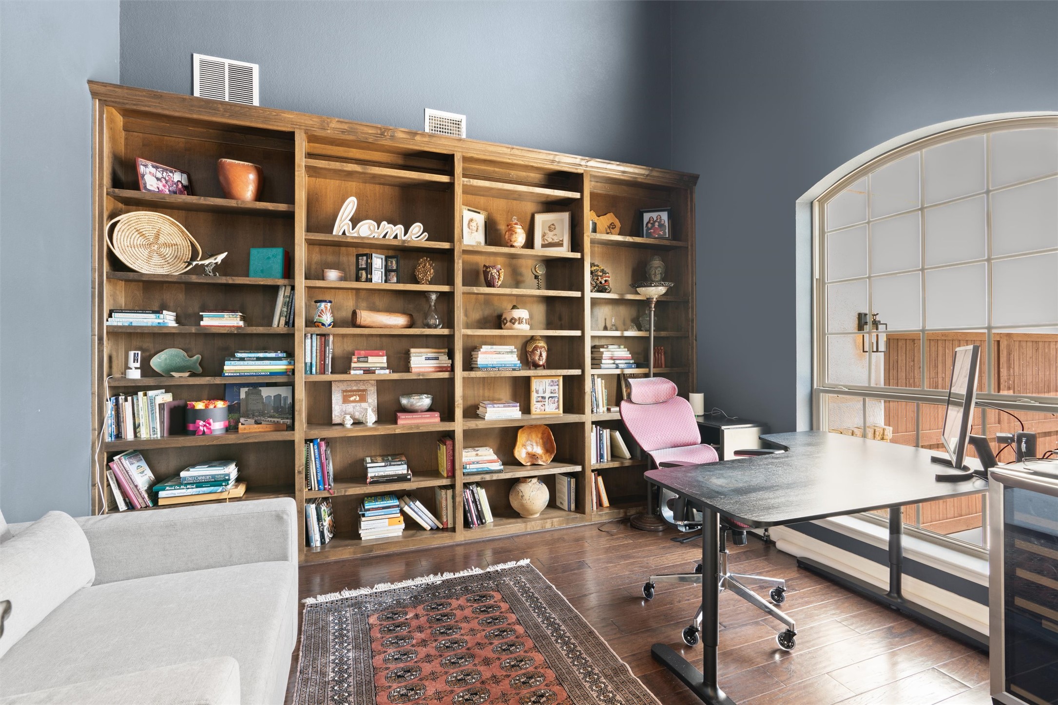 7716 Aria Loop Austin, TX 78736 - Photo 3 of 39 An ideal home office or study, this space offers extensive built-in shelving and a large arched window for abundant natural light.