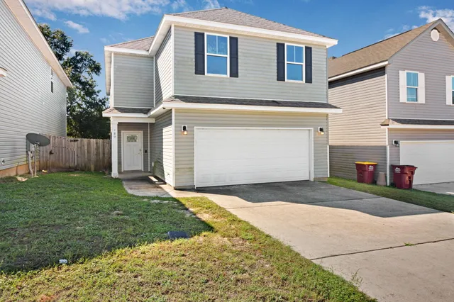 a front view of a house with a yard and garage