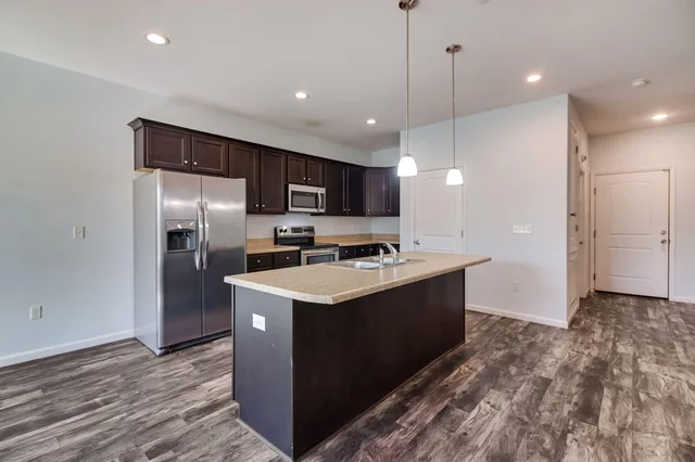 a kitchen with kitchen island a sink stainless steel appliances and cabinets