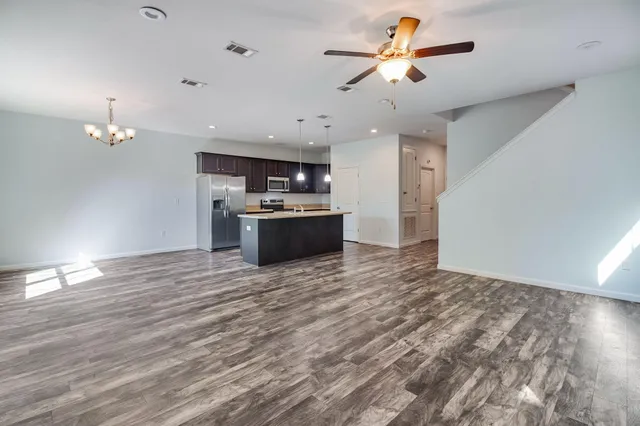 a view of a kitchen with a ceiling fan hardwood floor and a ceiling fan