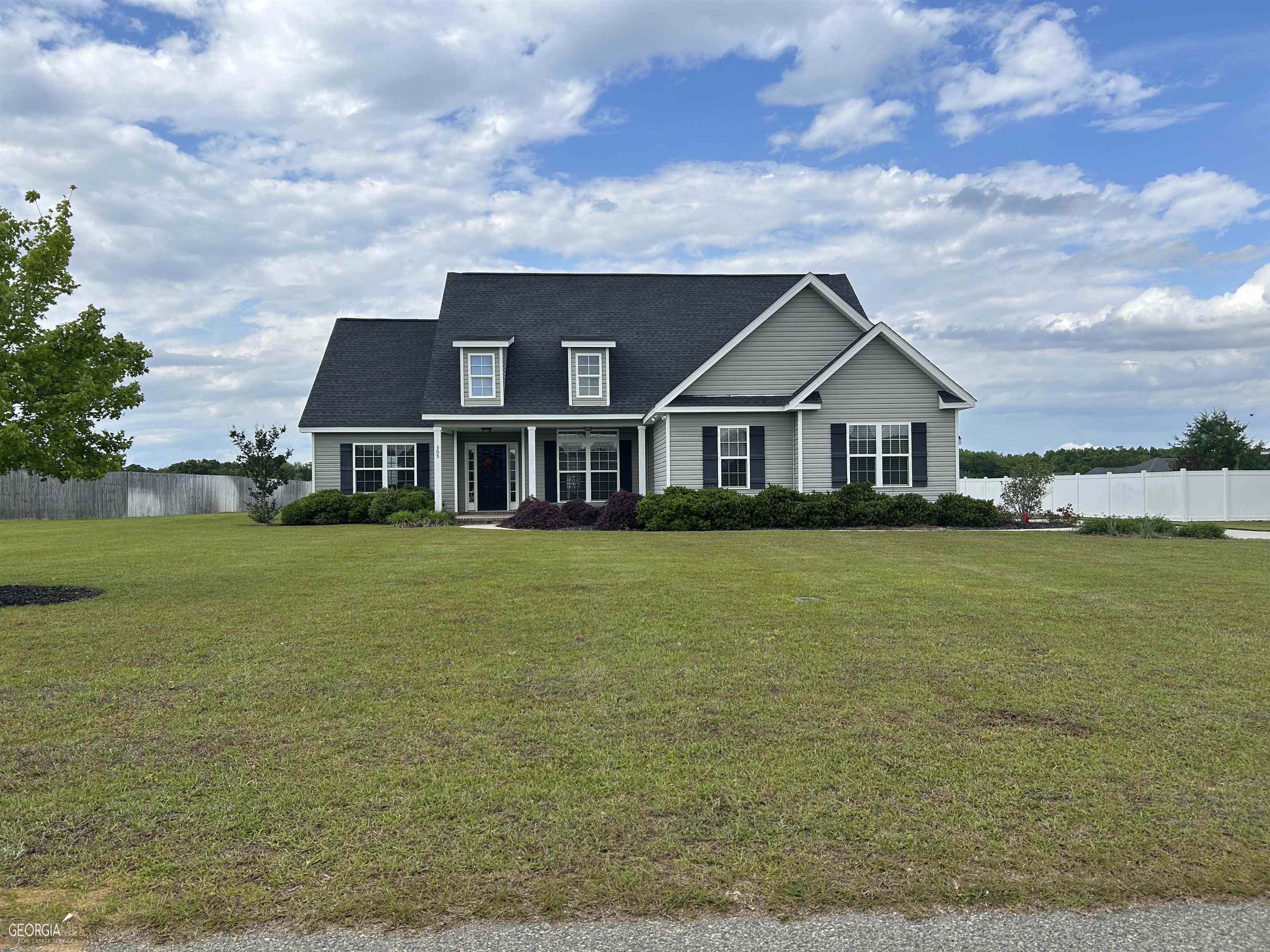 a front view of a house with a garden