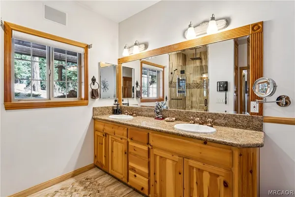 a bathroom with a granite countertop sink a mirror and bathtub