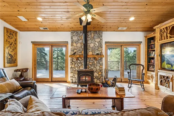 a kitchen with stainless steel appliances granite countertop a stove dining table chairs and wooden floors