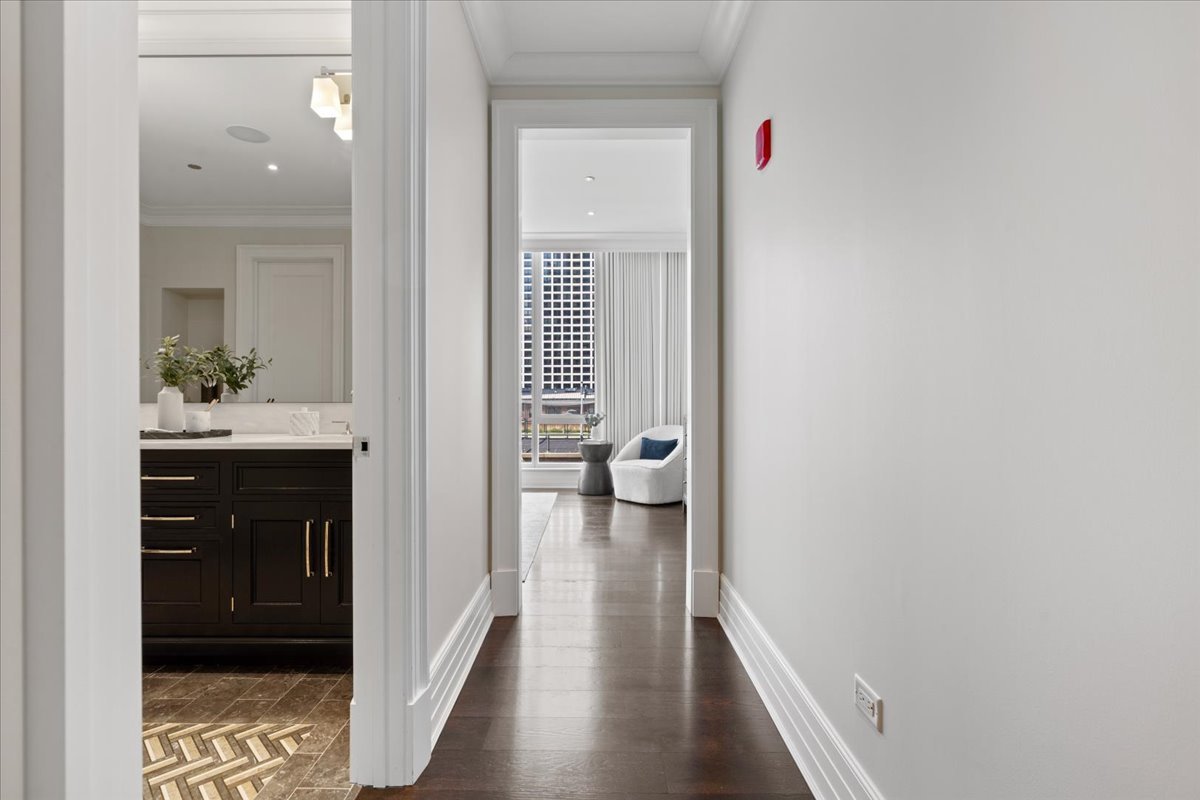 9 West Walton Street, Unit 702 Chicago, IL 60610 - Photo 21 of 38 a view of a hallway with wooden floor and a bathroom