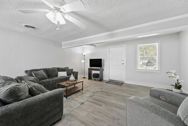 a living room with furniture and a ceiling fan