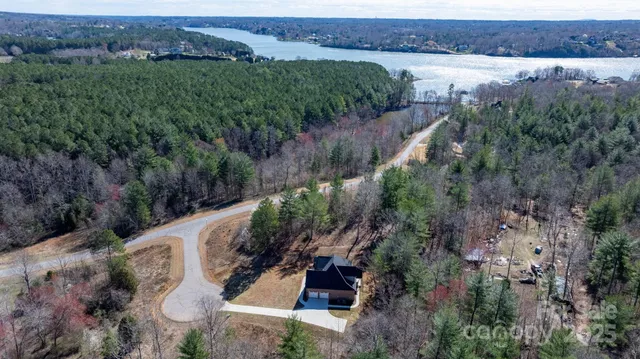 an aerial view of a house with a yard and lake view
