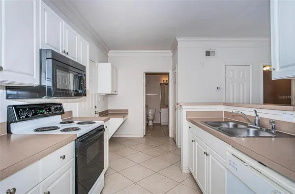 a kitchen with granite countertop a sink stove and cabinets