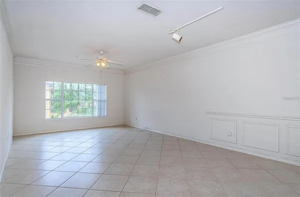 an empty room with windows and fan