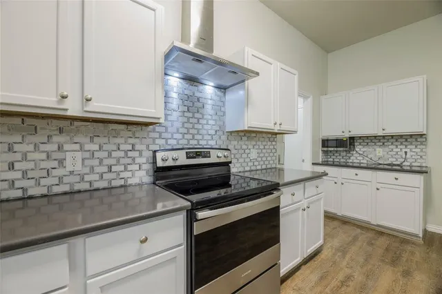 a kitchen with white cabinets and appliances
