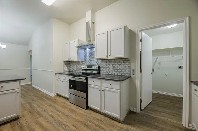 a kitchen with stainless steel appliances a stove and wooden floor