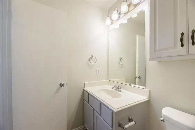 a bathroom with a sink a toilet and a mirror