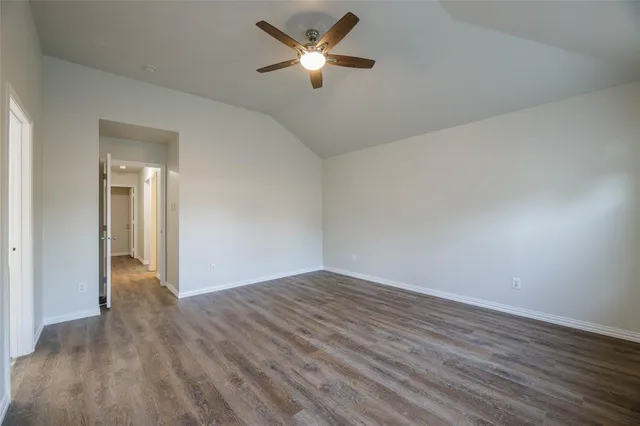 a view of room with a ceiling fan and wooden floor