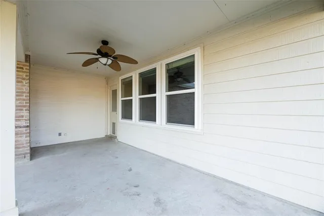 a view of a backyard with large trees and a barn